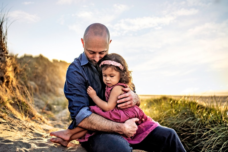 Family Photographer, a dad embraces his daughter outdoors
